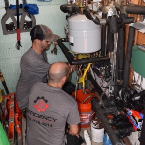 two men working on a water heater